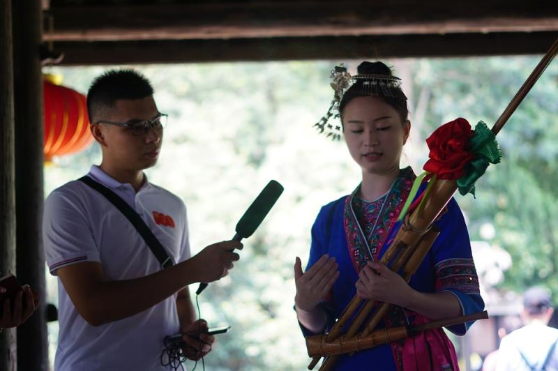 1-侗族寨民为我们大学生志愿者们讲解原生态的芦笛.jpg